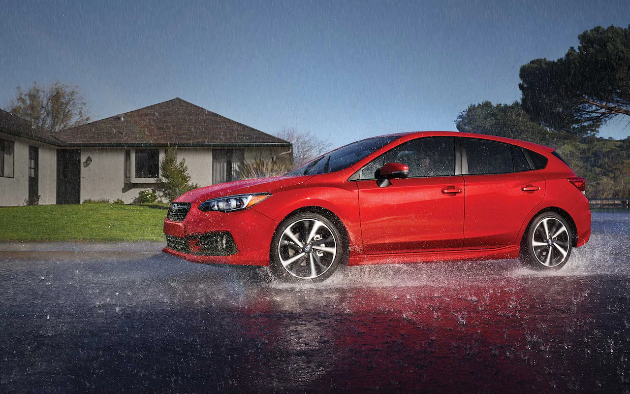 A 2022 Impreza sedan driving through a rain storm.