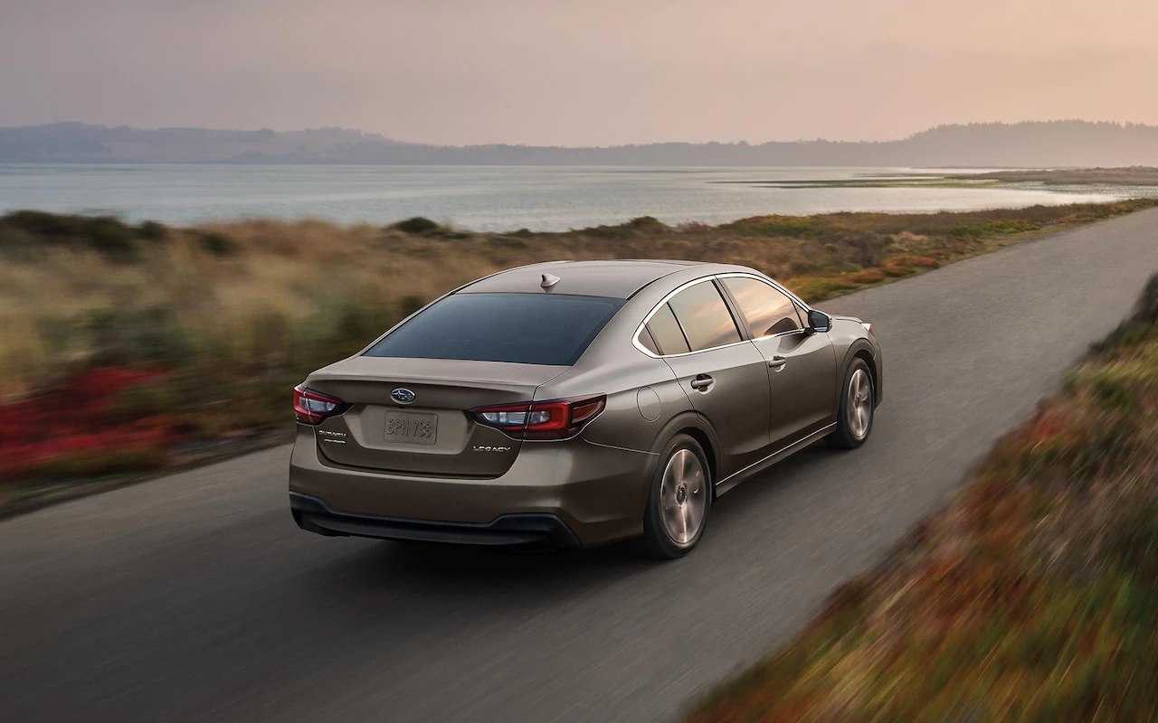 A 2022 Subaru Legacy driving on a coastal road.